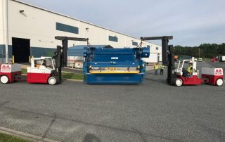 Tandem pick of a Heim stamping press with two (2) Versa-Lift forklifts.