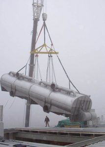 Installing 60’ long, 50,000 lb. flotation cell in recycled paper pulp mill. Note the rigging needed to equalize the load on this multi-point lift so that it could be tilted to fit through a roof opening shorter than flotation cell length