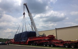 Crane-loading 200,000 lb. autoclave onto truck. Project required unloading of 170,000 lb. autoclave shell and bringing into building for final assembly and additional components, after which we removed and loaded the now 200,000 lb. unit as shown